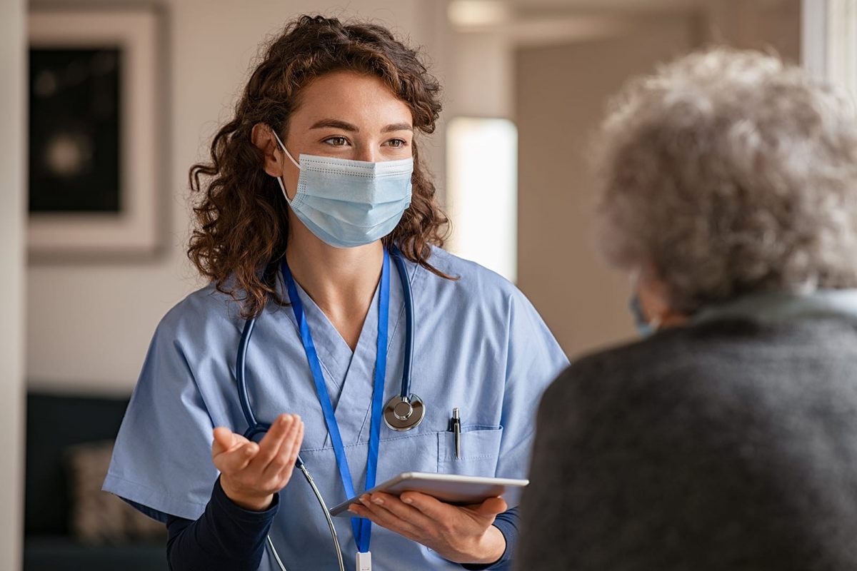 Doctor in mask speaking with patient